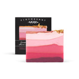 Pink gradient bar soap with gold toppings sits in front of its finchberry box