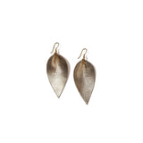 Pair of gold metallic leather earrings in the shape of an upside-down teardrop in front of a solid white backdrop