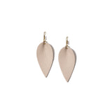 Pair of beige leather earrings in the shape of an upside-down teardrop in front of a solid white backdrop