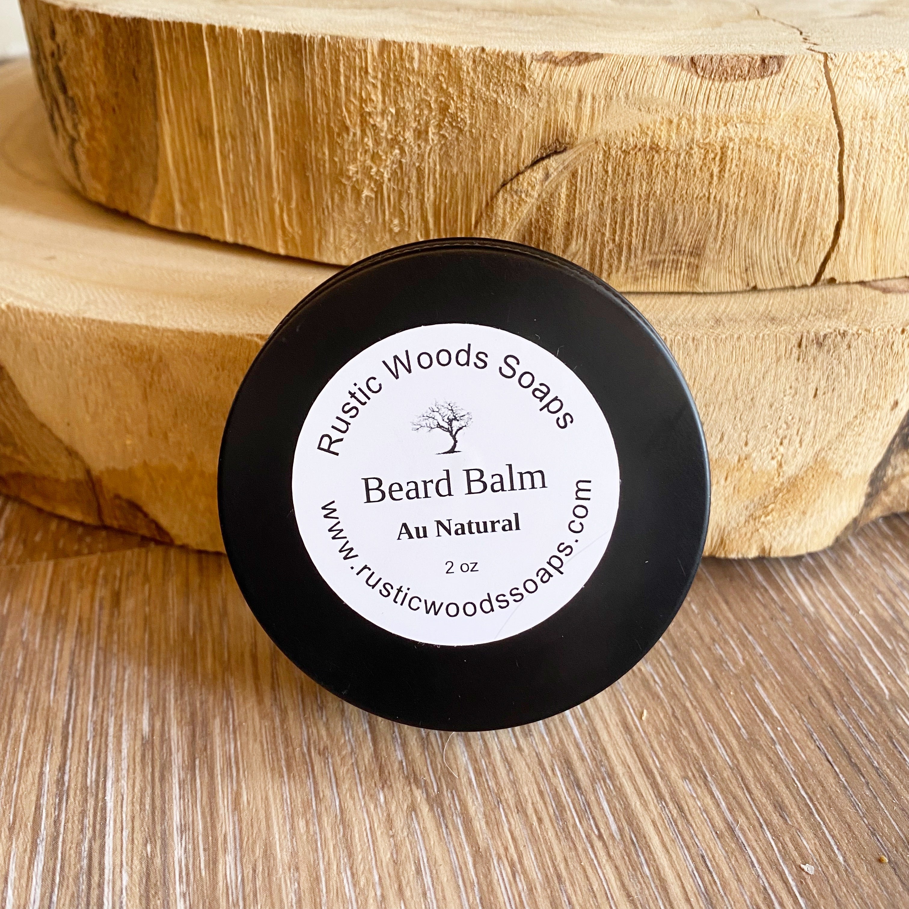 Black canister jar with white rustic woods soaps au natural beard balm label leans against wood pieces